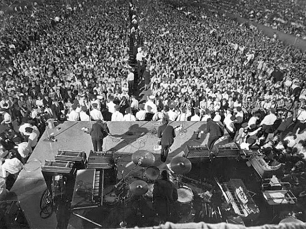 A photo of the Beatles bowing onstage after their performance at the International Amphitheater in Chicago on August 12th, 1966. Original source: The Pop History Dig, pophistorydig.com/topics/burn-the-beatles-1966/